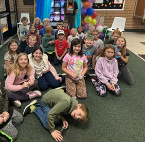 A class of students gets their picture taken in front of the new book vending machine.