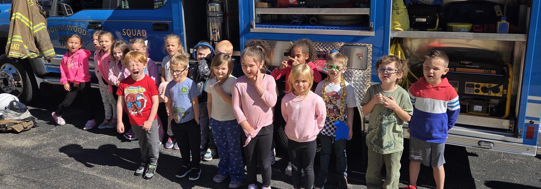 students posing in front of a fire truck