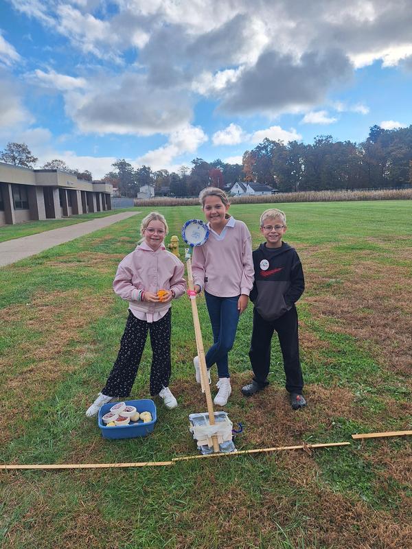 kids standing with a catapult