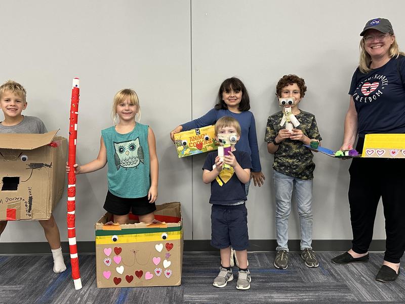 Participants of our Fantastic Family Nights posing with their cardboard creations and their teacher.