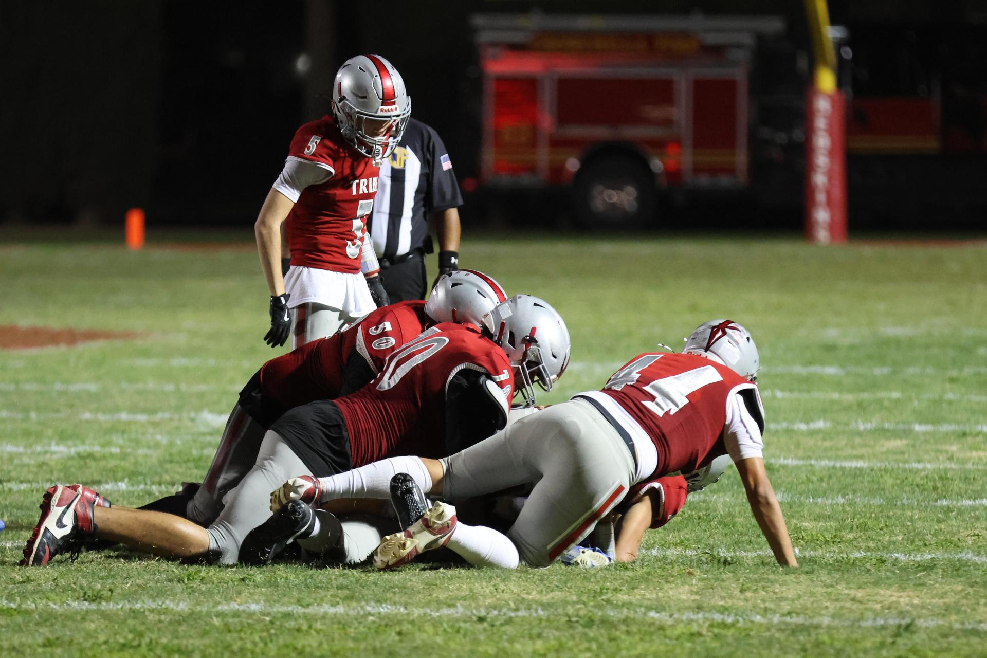 Varsity football players in action against Parlier 76