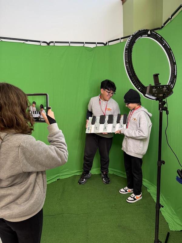 students filming in front of a green screen
