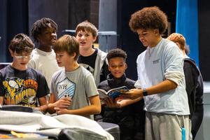 Cayden leads performers in warm-ups