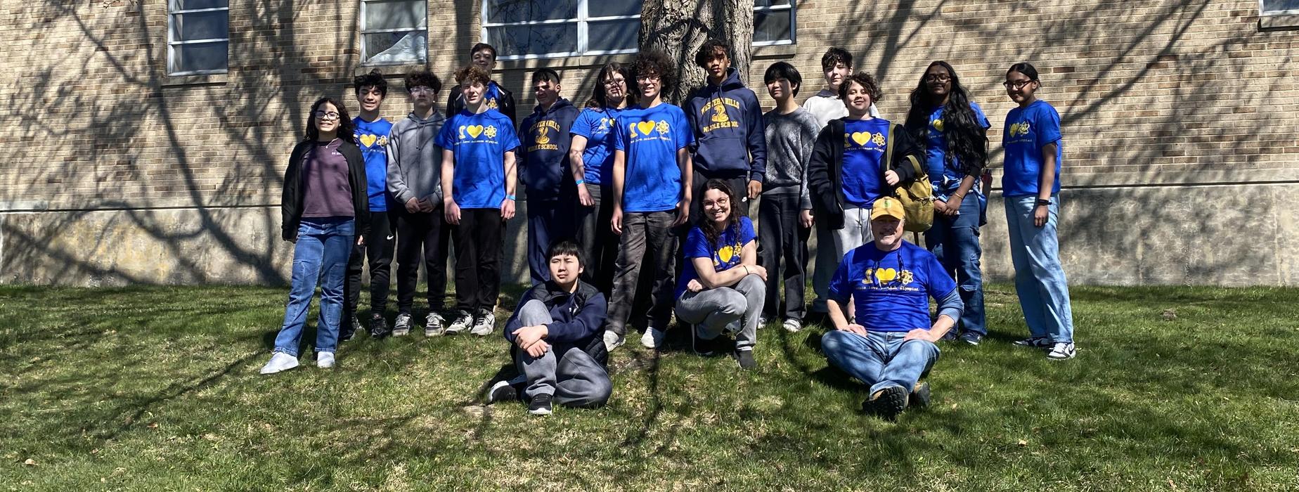The WHMS Science Olympiad team pose together outside in front of a tree.