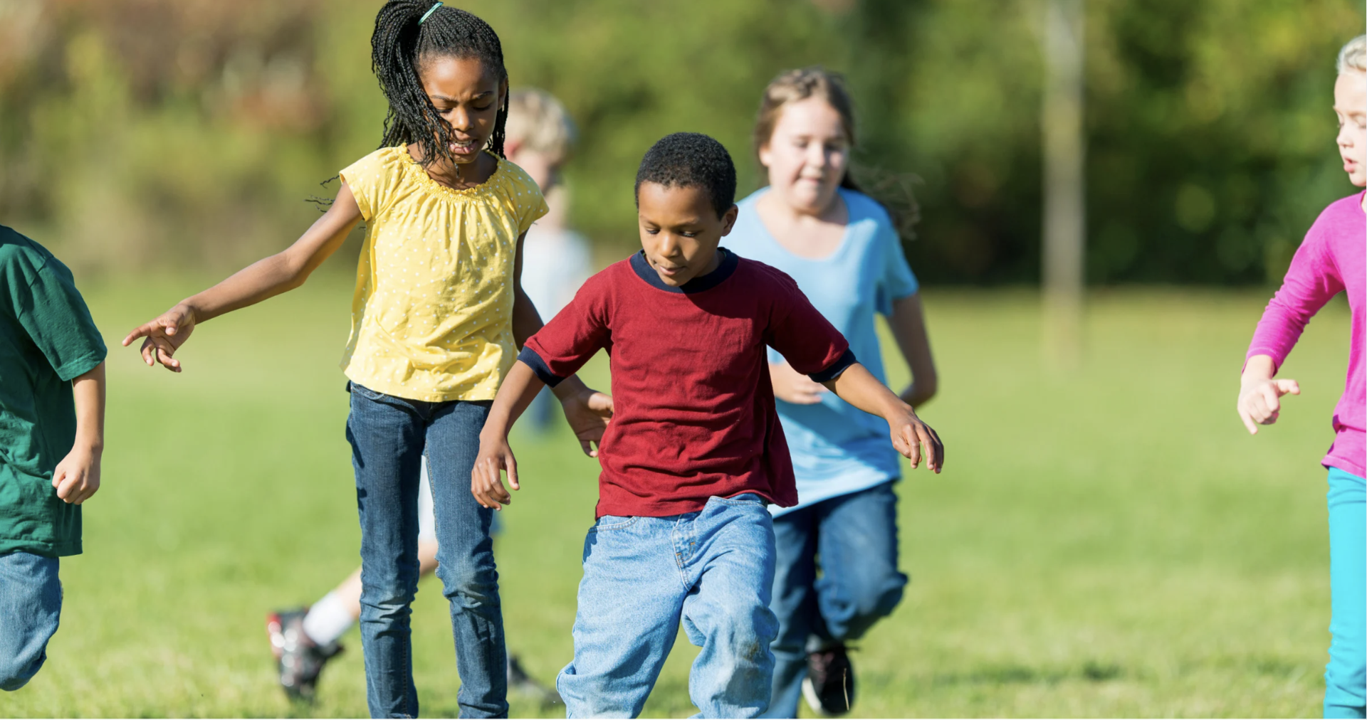 Kids play on a grassy field.