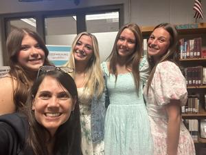 Smiling students stand with school projects