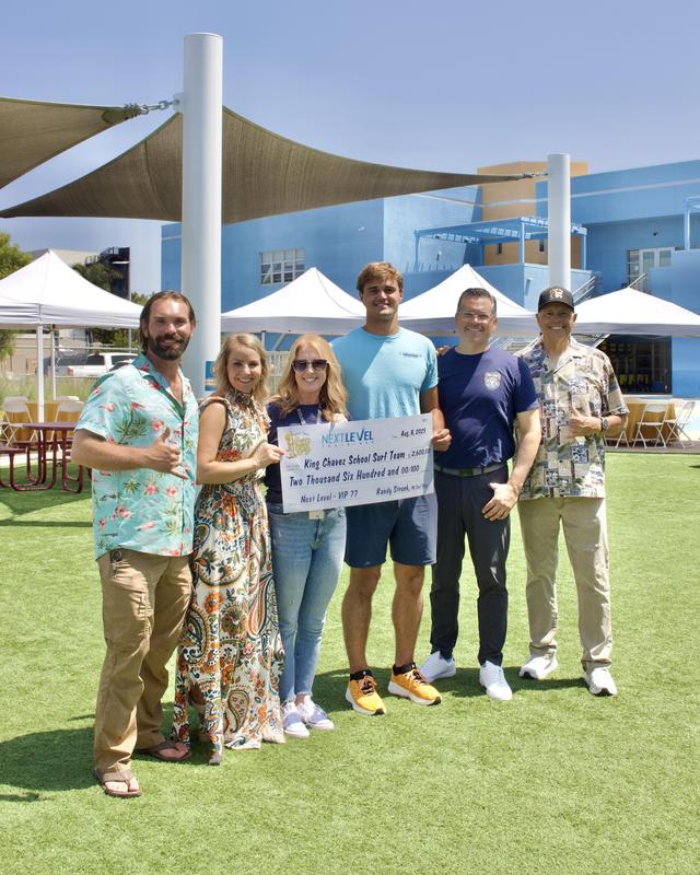 PB Surf Show Owner and KCNS Staff pose for a photo
