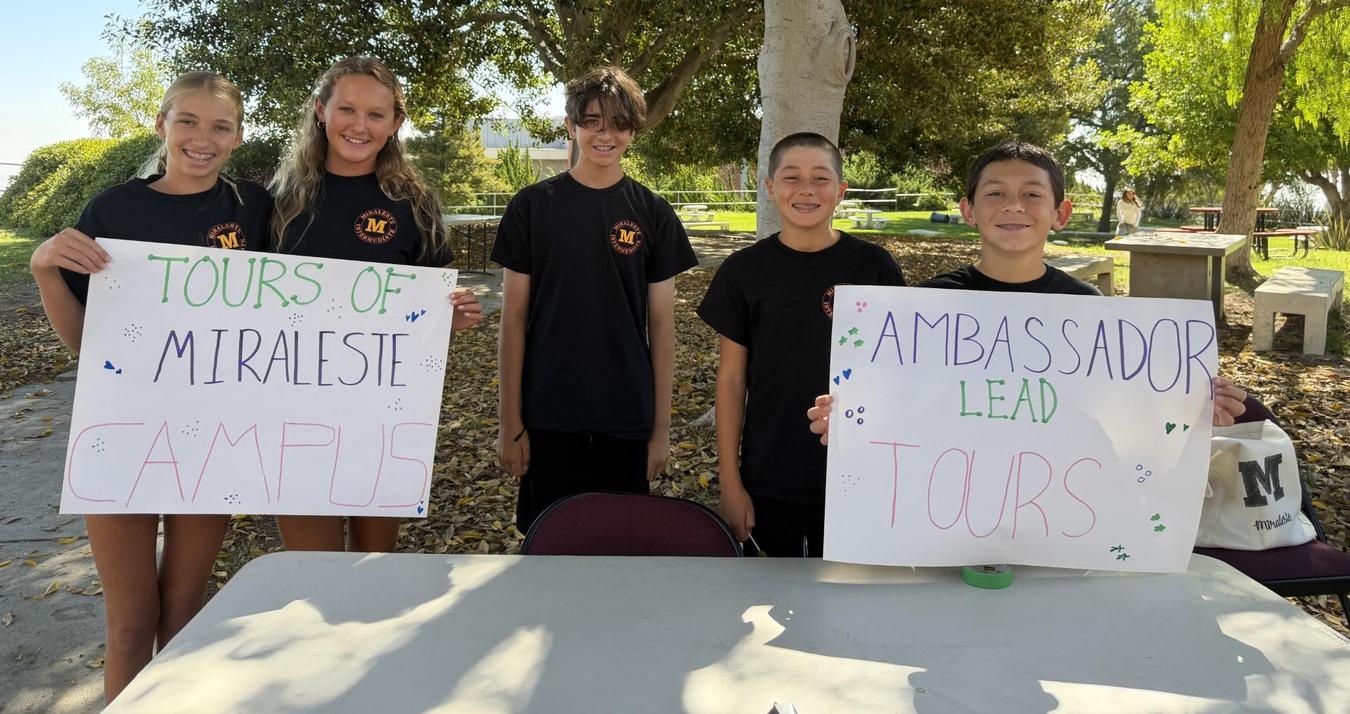 Group of students promoting campus tours with signs.