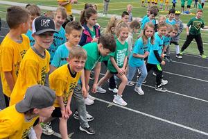 Runners from the various schools line up at Warrior Stadium for a group run