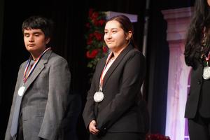 MHS Students standing on stage receiving state medals