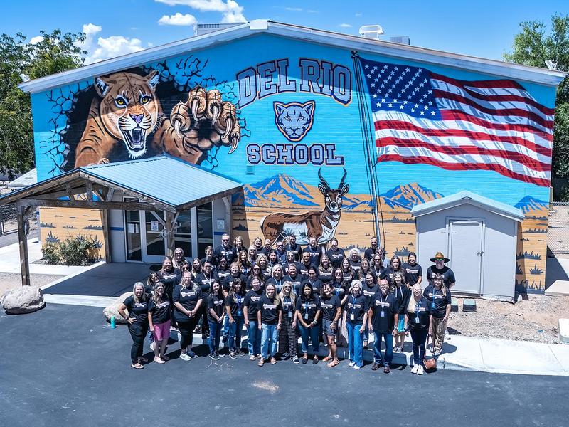 all DRS staff in front of new mural on entrance of school building