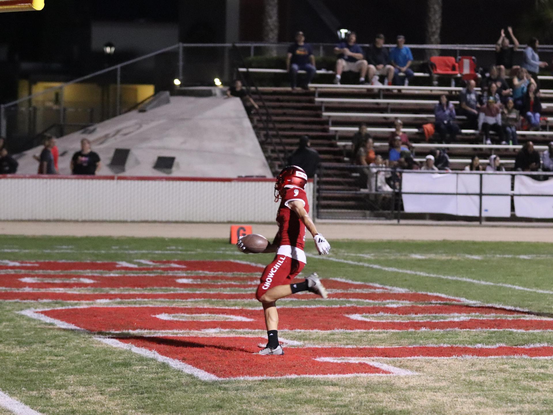 varsity football players in action against Riverdale