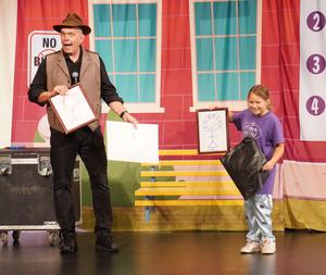 A show performer does a magic trick with a student.