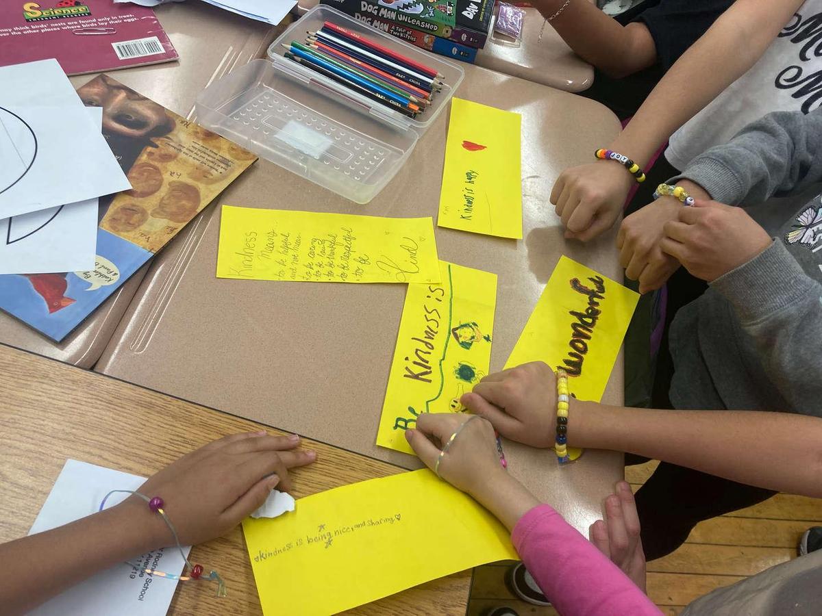 Students creating colorful cards with handwritten messages.