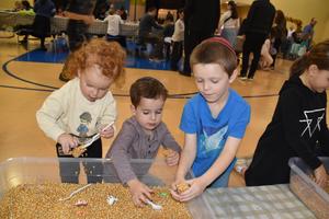Three kids enjoying the corn ac tivity
