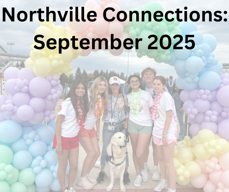 group of students posing together under a colorful balloon arch