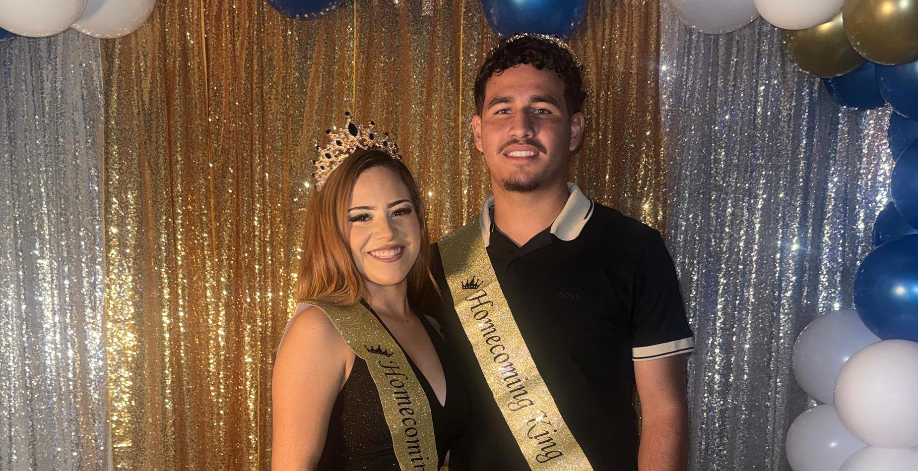 Lifeline Homecoming 2026 king and queen smiling beneath the blue, white, and gold balloon arch.