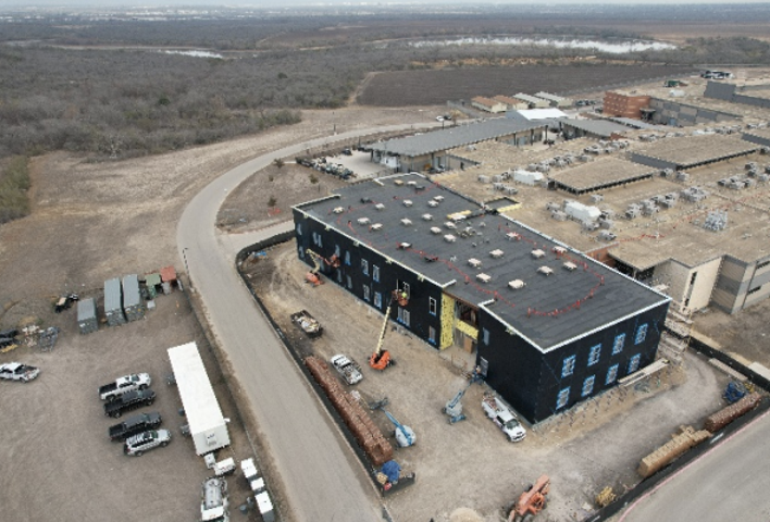 Aerial view of a large building under construction in a rural area.