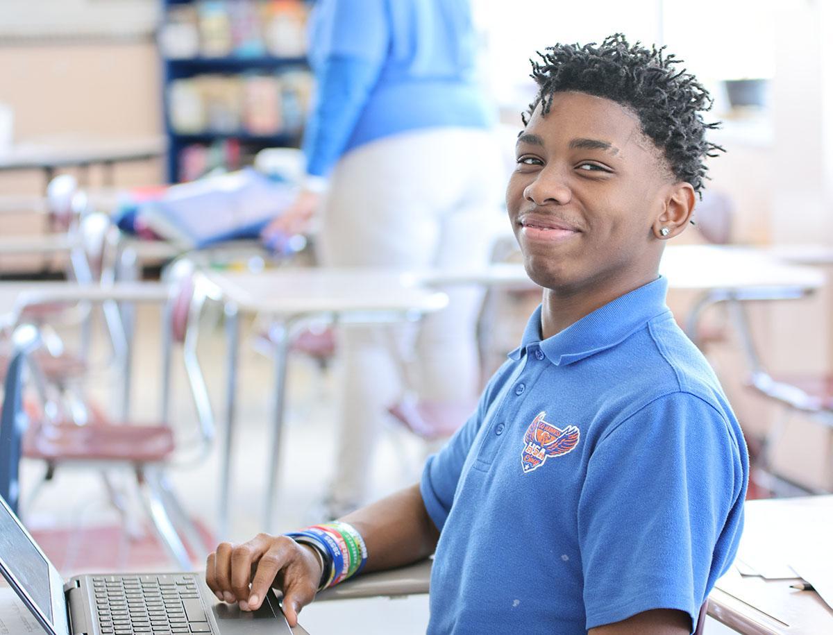 Student working on a notebook in a classroom.