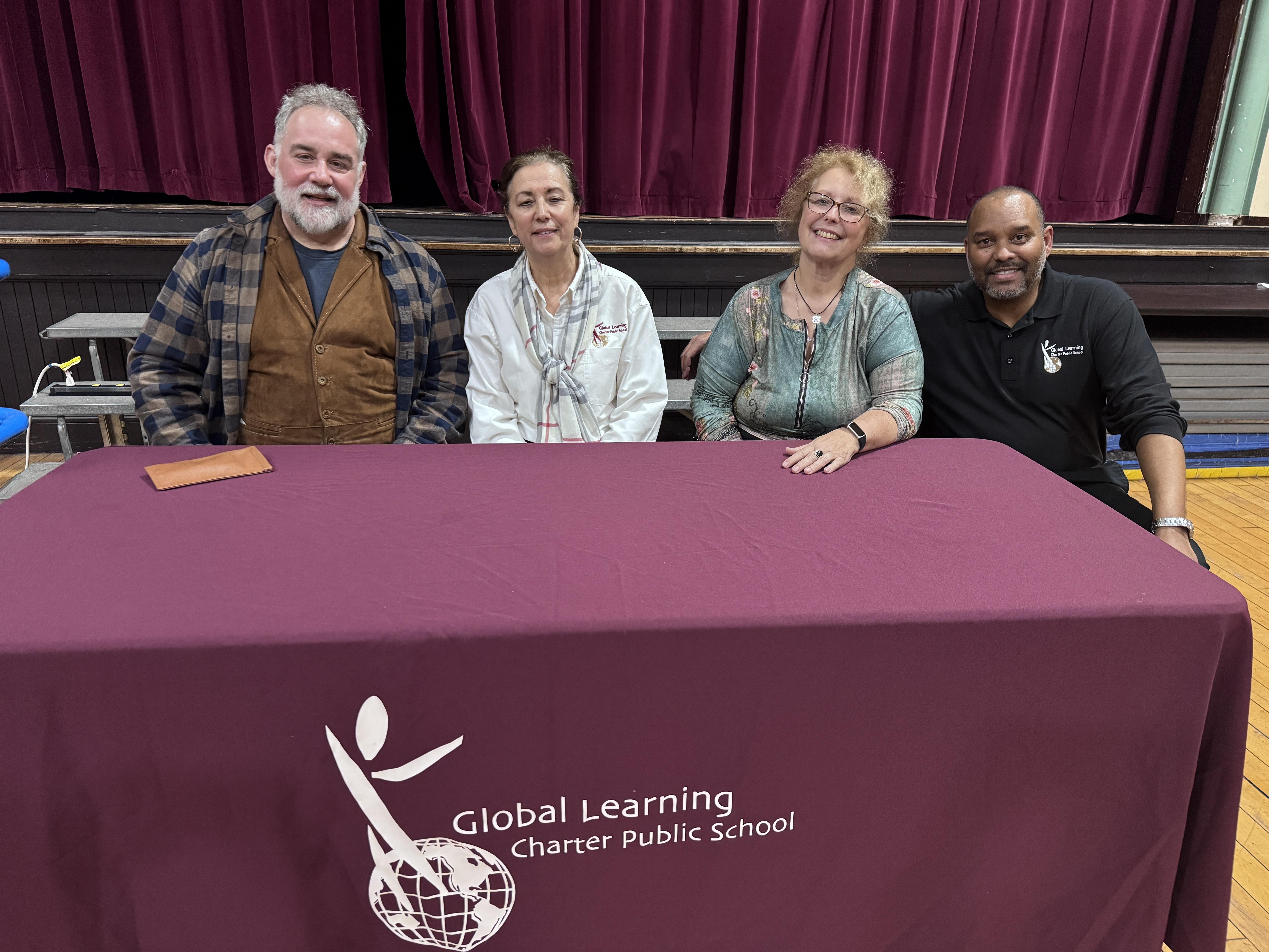 four adults sitting at a table