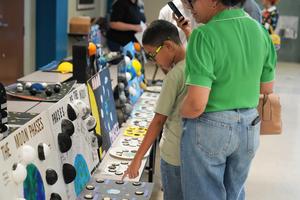 student and woman look at planet science display.