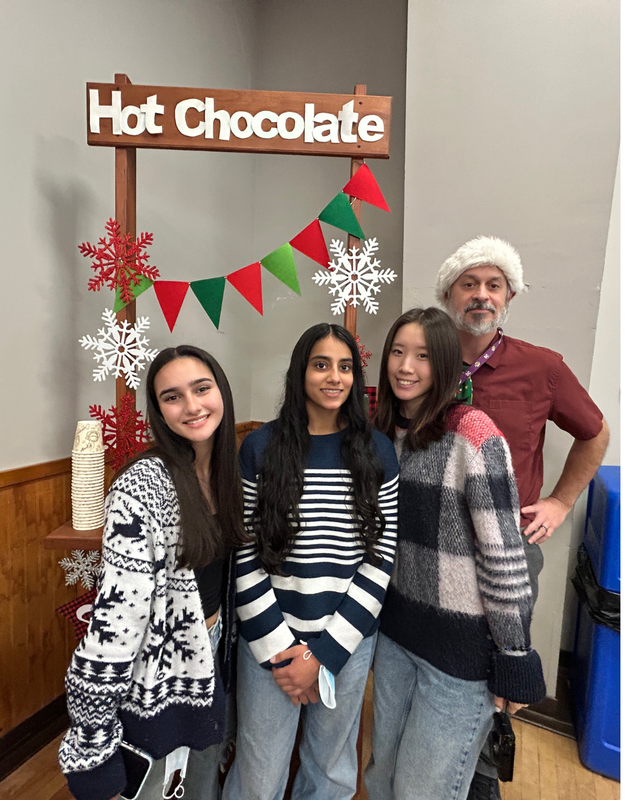 Key Club members in front of hot chocolate sign