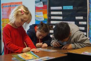 Arco Iris students work on classwork in a classroom.