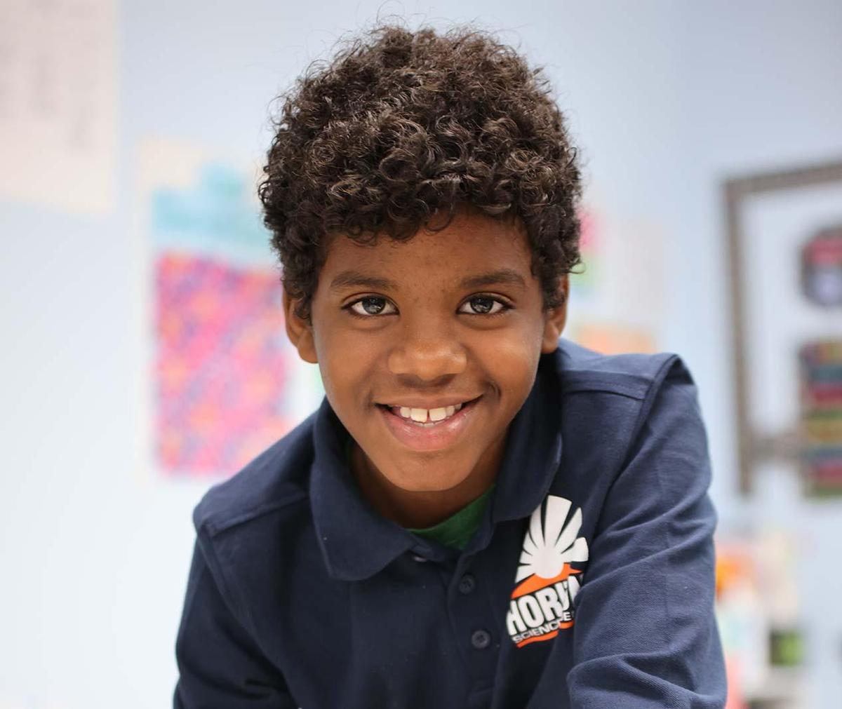Student smiling in a classroom.