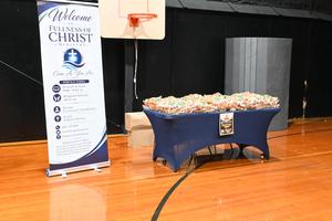 Sign for Fullness of Christ Ministry next to a table of candy.