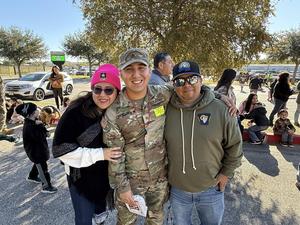 man in army uniform standing between his parents