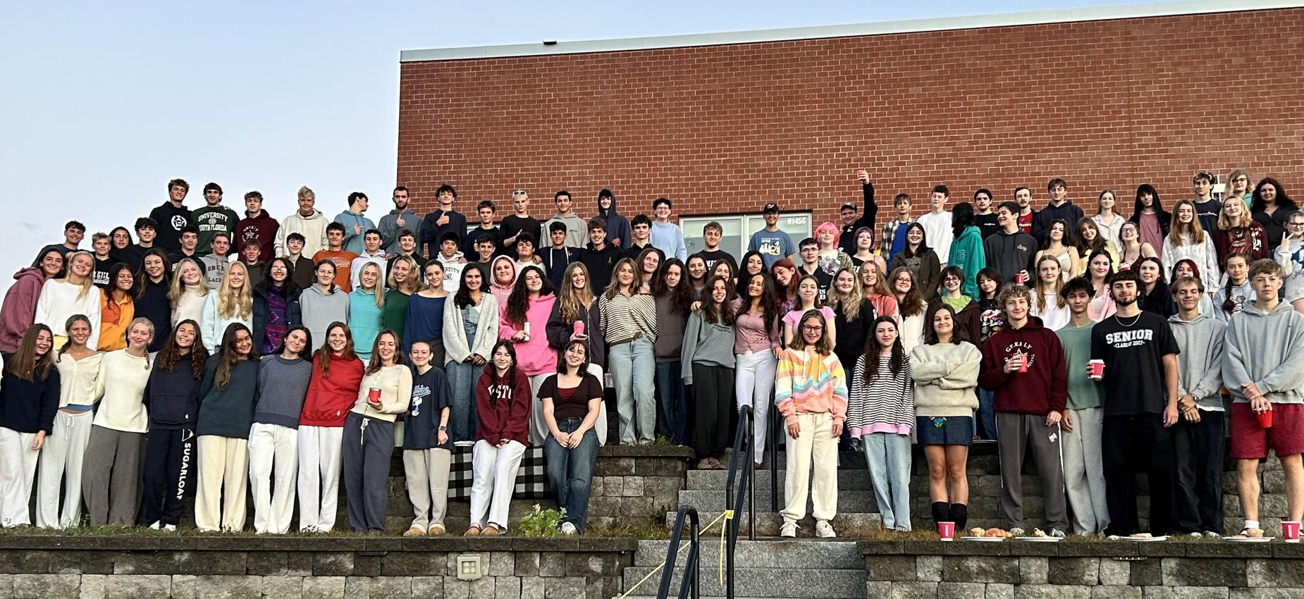 Large group of students posing together on outdoor steps.