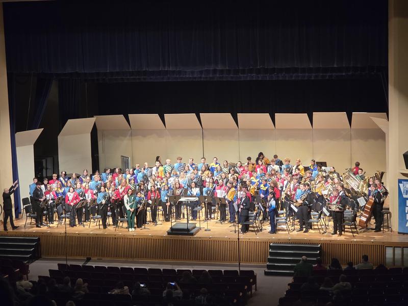 large group of high school band members on a stage