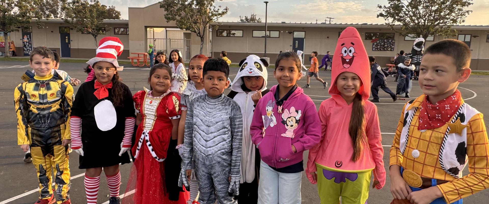 Group of children in costumes, including superheroes and cartoon characters.