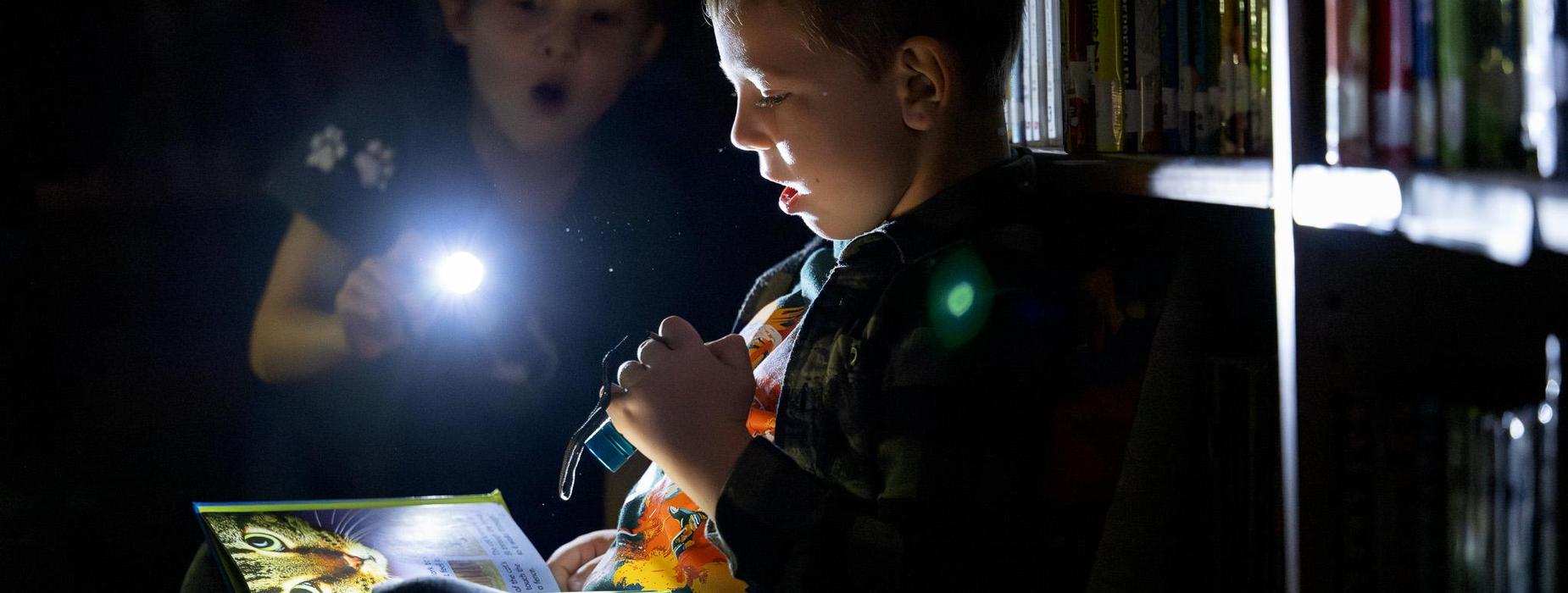 Students reading by flashlight