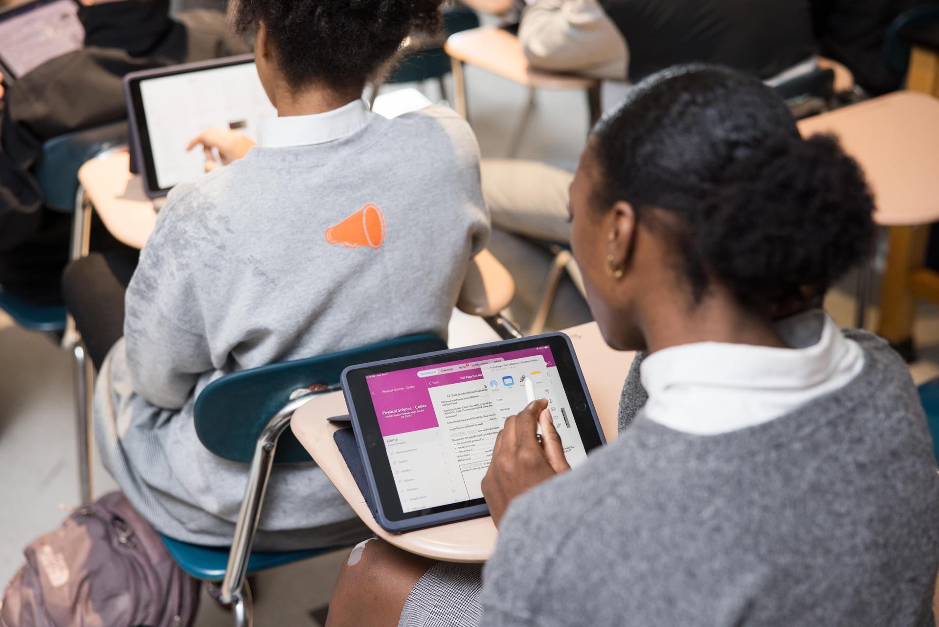 Student seated at a desk working on an iPad.
