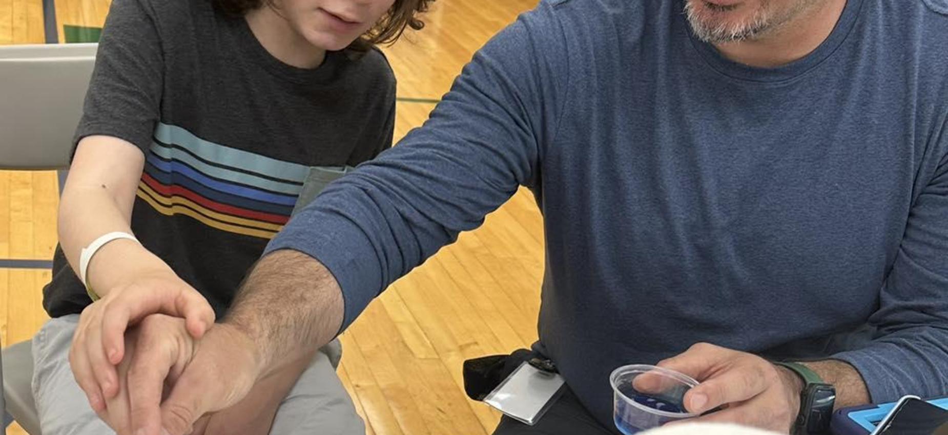 Adult and child participating in a hands-on activity, exploring textures.