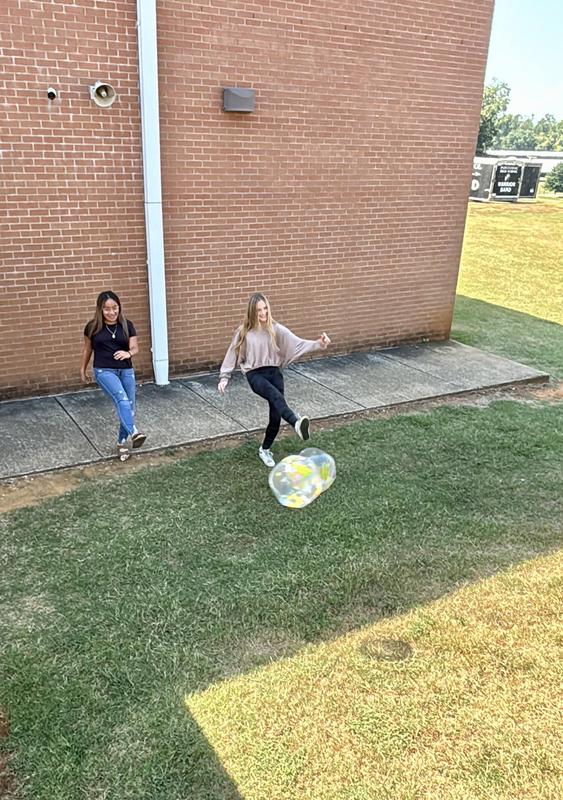Girls kick the balls up the hill