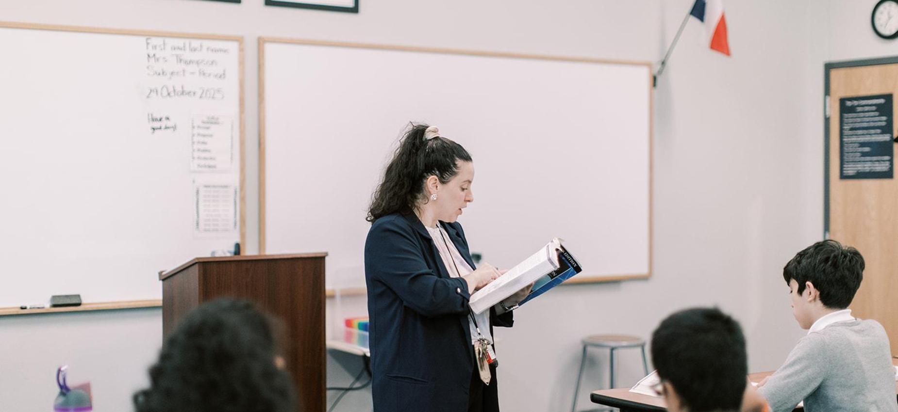 Teacher reads from a book during class
