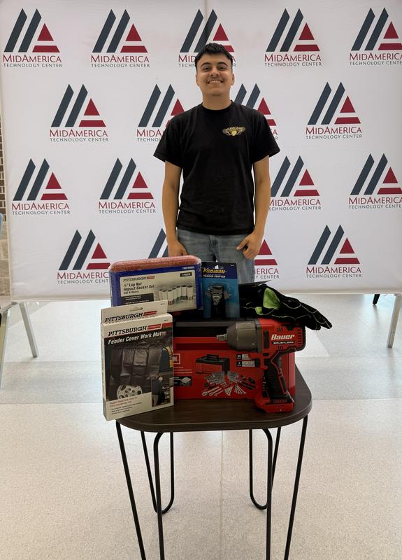 student standing behind a small table with different tools