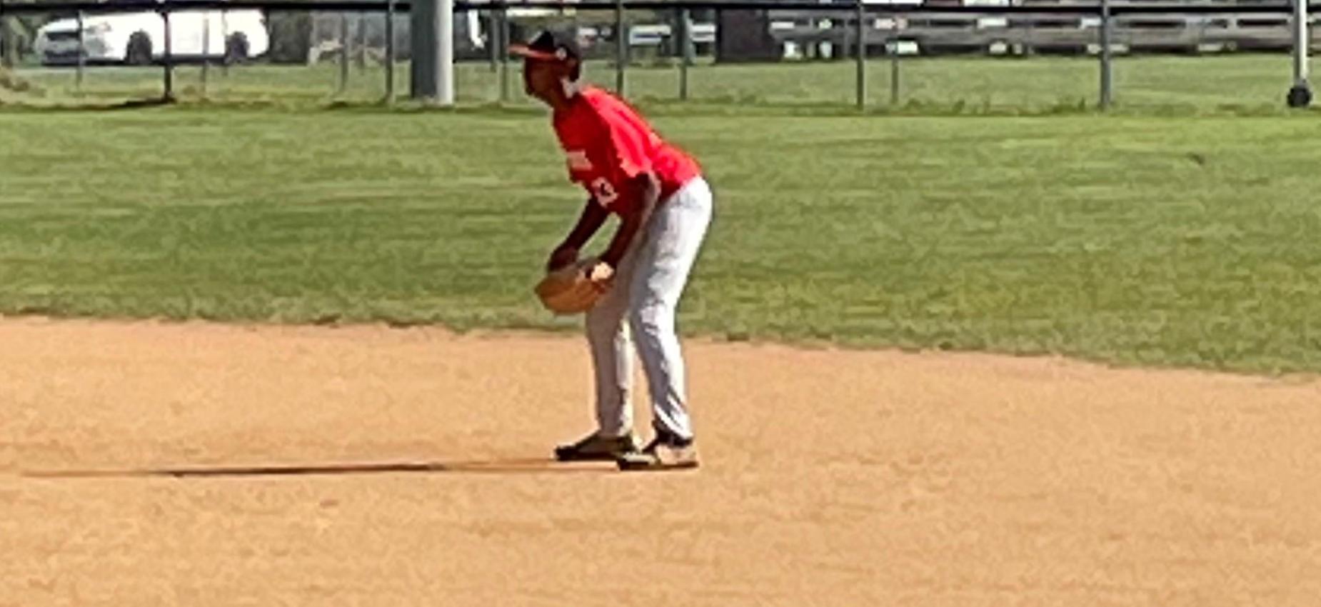 A baseball player stands in the infield.