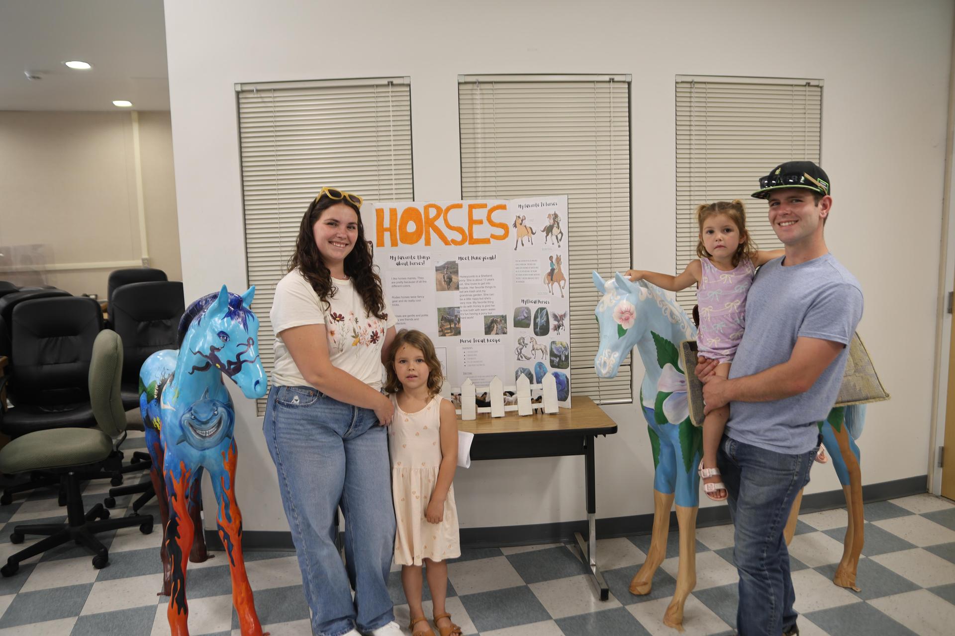 Homeschool family standing near their presentation.
