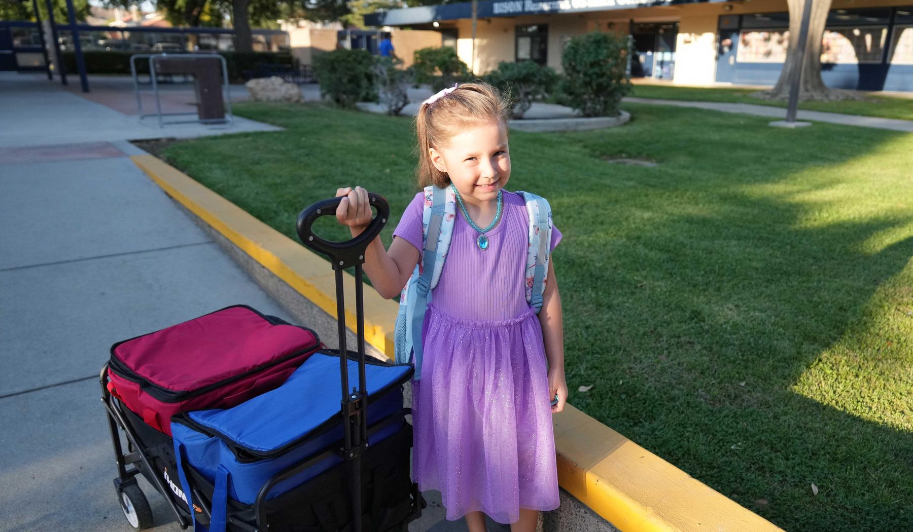elementary girl pulling wagon with Breakfast in the Classroom items