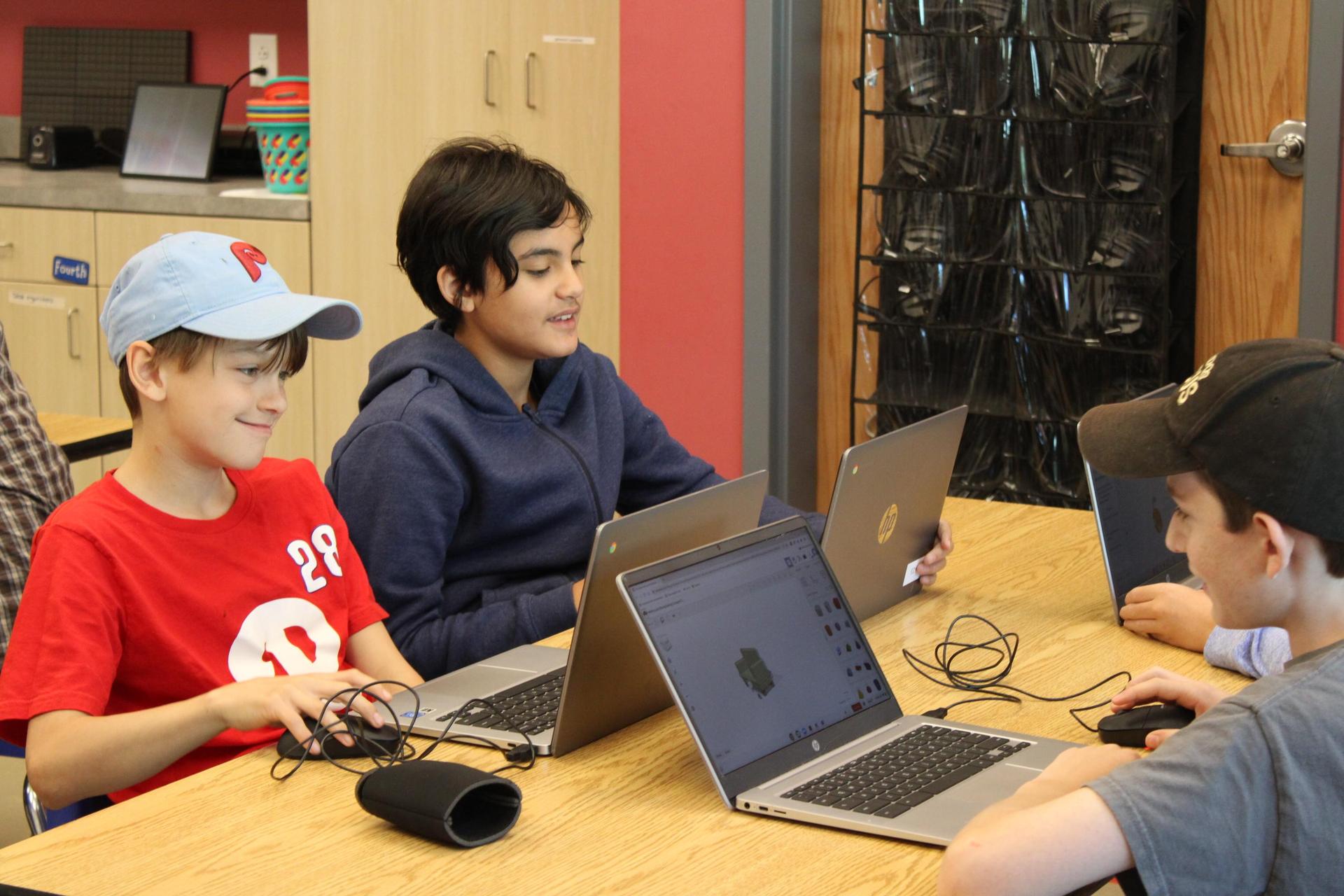 A group of three students working on chromebooks