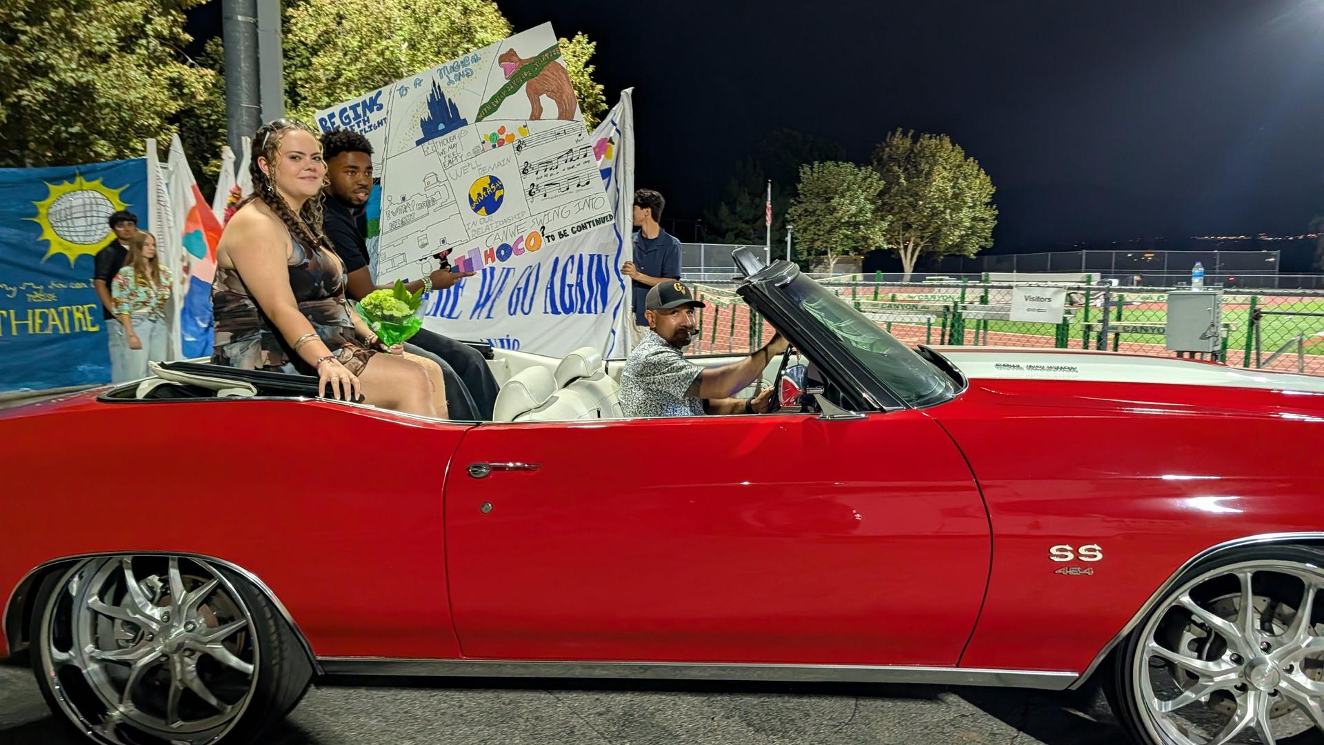 A car with students and staff member in the homecoming parade.