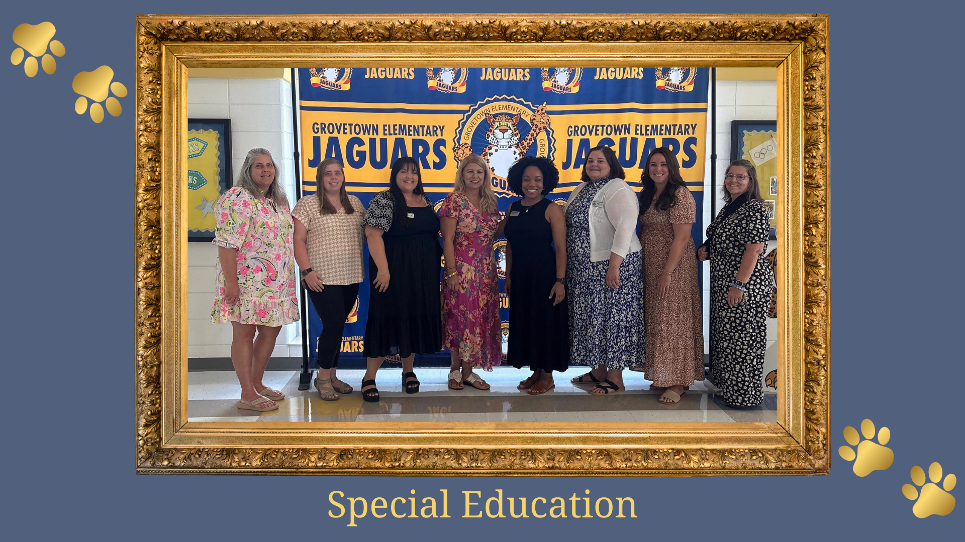 Eight women stand together in front of a 'Grove Town Elementary Jaguars' banner for Special Education.