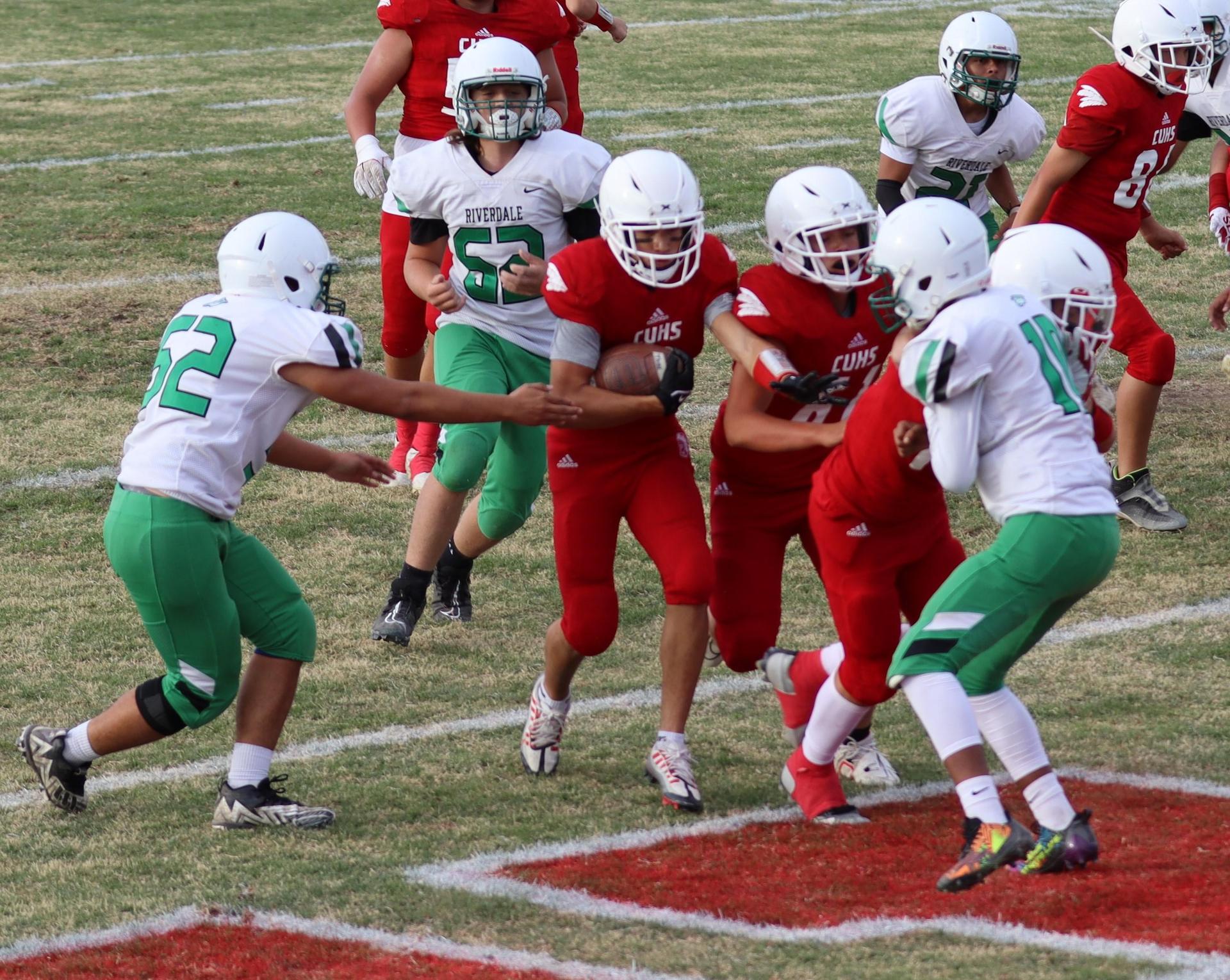  junior varsity football players in action against riverdale