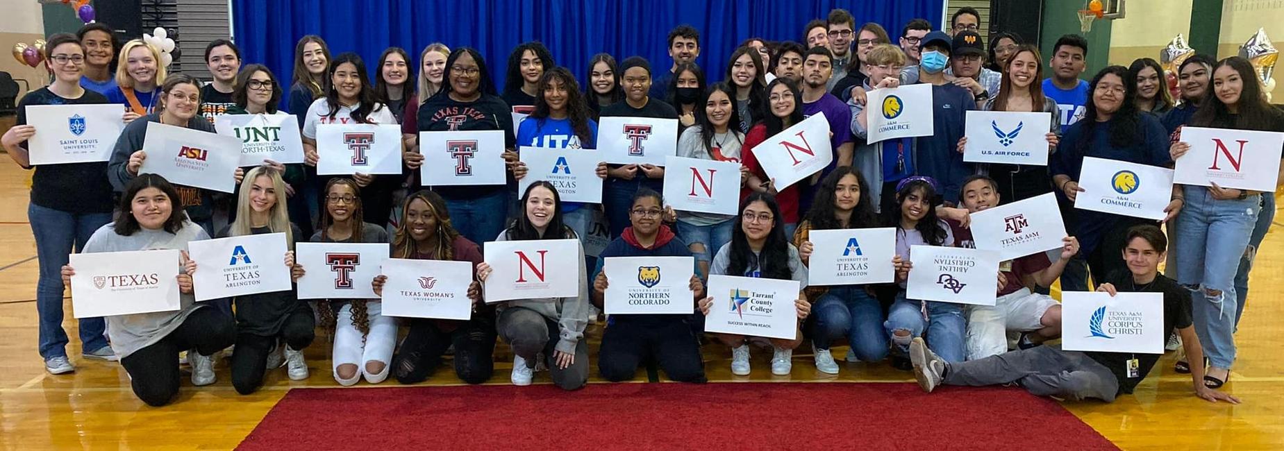 large group of teens holding college posters