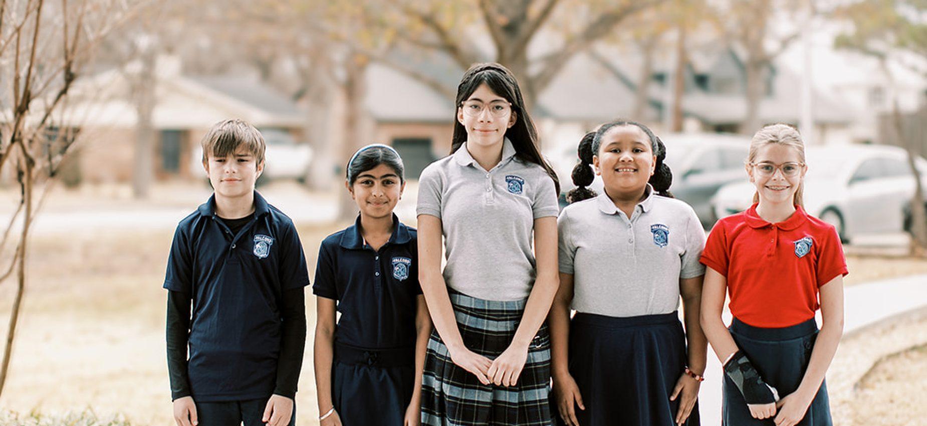 Five Coppell Classical Academy students in uniform standing together outside on campus