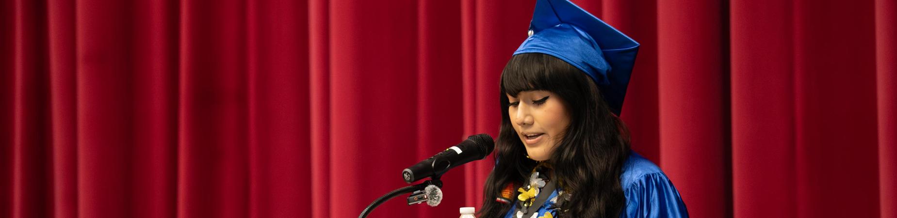 Picture of a student giving a speech during graduation.