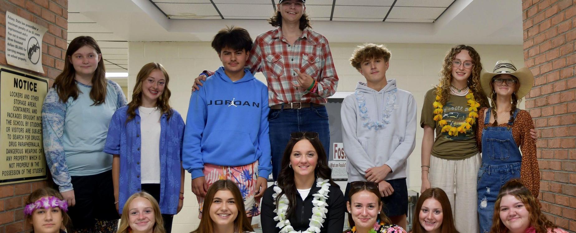 Group of students in casual attire posing together indoors with festive accessories.